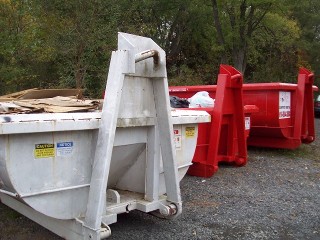 White and red rental dumpsters of various sizes
