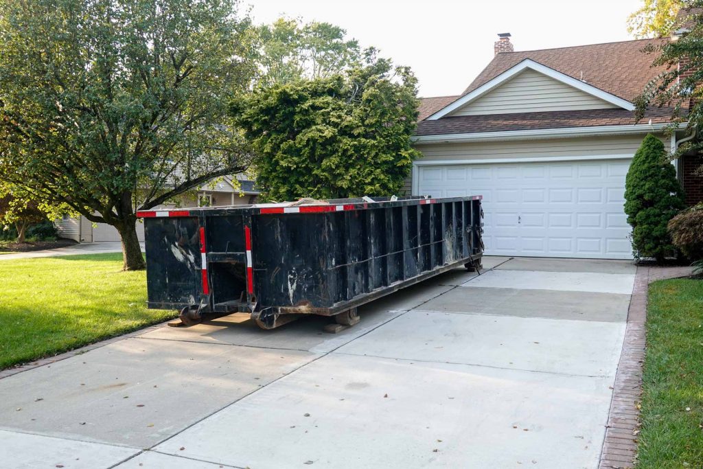 Black rental dumpster in home's driveway